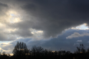 a cloudy sky with a few trees and a few clouds
