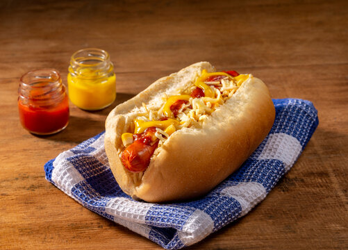 hot dog with two little jars with mustard and ketchup.
