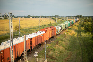 Fototapeta premium Freight train with wagons and containers on the railway station.