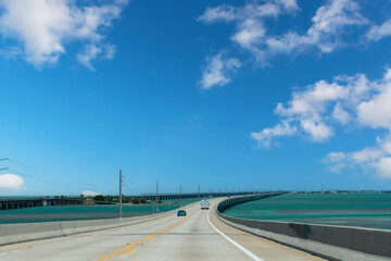 Drivers&rsquo; perspective over the Seven Mile Bridge or Florida State Road A1A towards Key West, FL, USA and cars on the road with on left side the Old Seven Mile Bridge