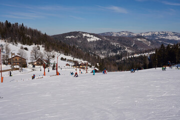 People skiing at landscape of Silesian Beskid on European Bialy Krzyz in Poland