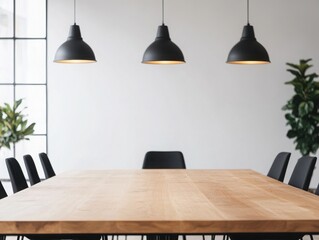 Modern workspace featuring a wooden table with pendant lights and decorative plants, perfect for collaboration and creativity.
