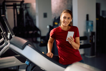 Young smiling sportswoman exercising in gym and looking away.