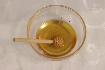 Honey bee in a bowl of honey.A bowl with honey and a dipper to take honey
