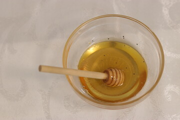 Honey bee in a bowl of honey.A bowl with honey and a dipper to take honey
