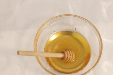 Honey bee in a bowl of honey.A bowl with honey and a dipper to take honey
