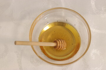 Honey bee in a bowl of honey.A bowl with honey and a dipper to take honey
