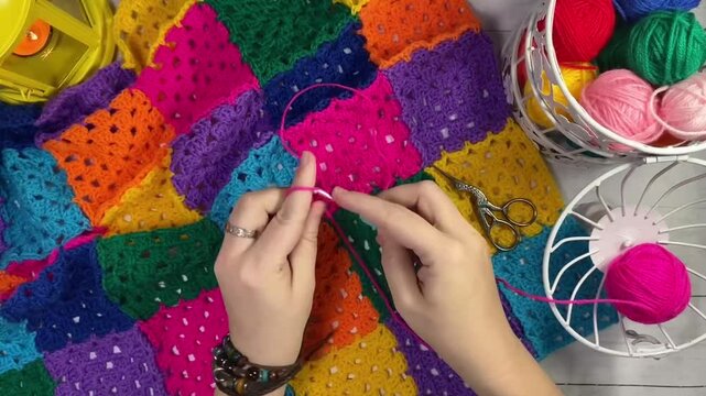 Crocheting granny square blanket plaid process and woman's hands hobby handmade handiwork clews and hook cozy winter autumn fall video	
