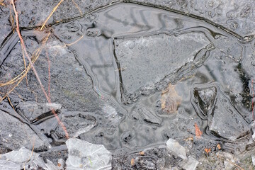 Fototapeta premium natural texture of gray white pieces of ice in a frozen puddle outside