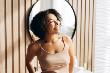 Young woman smiling and relaxing in modern bathroom