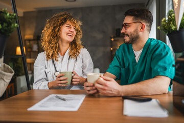 two doctors colleagues man and woman enjoy on break with coffee at home