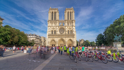 Fototapeta premium Front facade of cathedral of Notre Dame de Paris, with square full of people in front timelapse hyperlapse