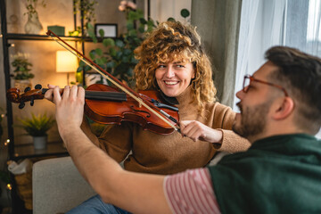 boyfriend teach girlfriend how to play violin practice at home