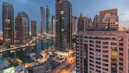 Obraz premium Aerial view of Dubai Marina residential and office skyscrapers with waterfront night to day timelapse