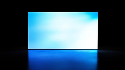 A glowing blue screen emits soft light in a dark environment, creating a serene and minimalist atmosphere.