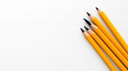 Fototapeta premium A collection of yellow pencils arranged on a white surface.