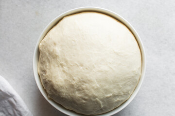 Bread dough that has doubled in size, dough that has risen, proofed dough in a white bowl