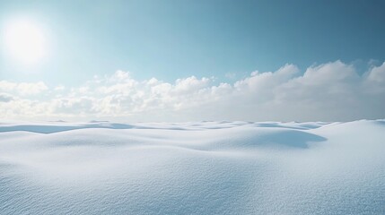 Fototapeta premium A serene winter landscape blanketed in snow stretches out beneath a clear blue sky, with soft, fluffy clouds gently drifting by, contributing to the peaceful ambiance of the scene