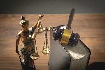 Lady Justice statue, judge gavel, book on the table.
