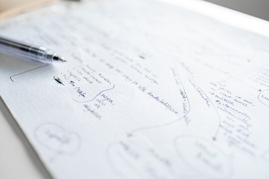 Close-Up of Handwritten Notes on White Paper with Pen