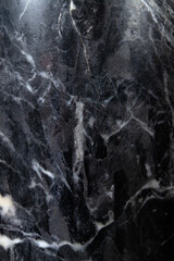 Close-up black marble texture with intricate white veins showcasing a polished surface for design and decor