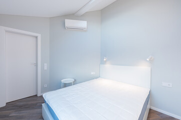 Modern Minimalist Luxury Home Bedroom Interior with King Size Bed and Natural Light. AC on the Wall