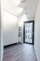 Modern Home Hallway With Wooden Floor and White CLoset, Heater Featuring Contemporary Lighting. Home Entrace