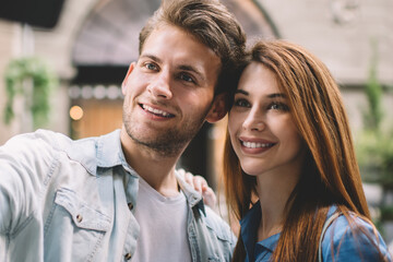 Fototapeta premium Happy couple taking selfie with smartphone on street
