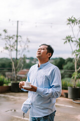 Fototapeta premium A Southeast Asian man enjoying a cup of coffee in the morning