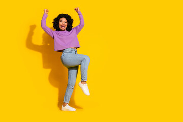 Full size photo of nice young woman raise fists empty space isolated on yellow color background