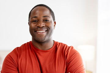 Happy middle aged African American man posing at camera at home