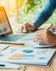 Fototapeta premium Business Professional Analyzing Data and Creating Reports with Laptop, Graphs, and Notes in Bright Office Environment
