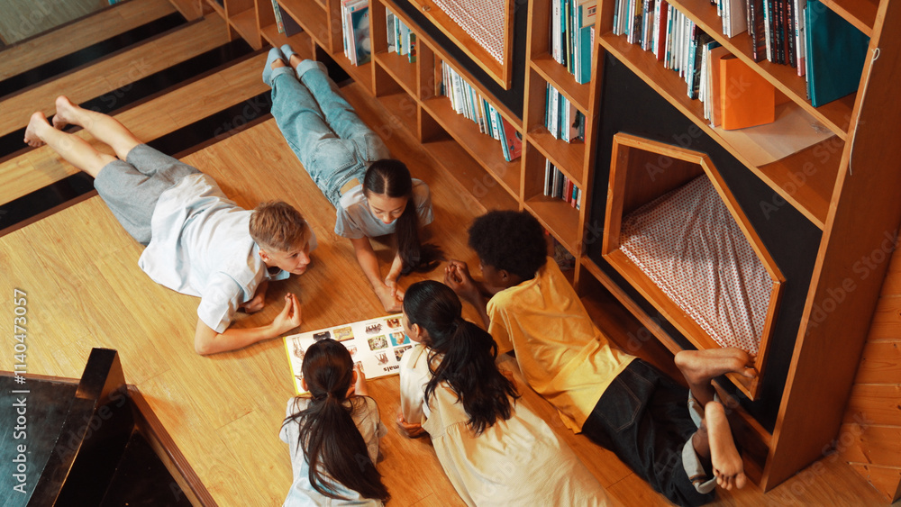 Poster group of diverse children lying down in circle while reading a book at library. top view of girl sha