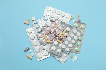 Various blisters with tablets on a colored background