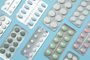 Various blisters with tablets on a colored background