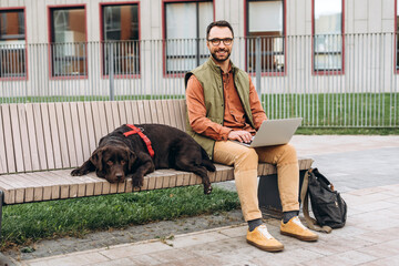 Middle aged man, freelancer wearing stylish eyeglasses, using laptop, copywriter typing on keyboard