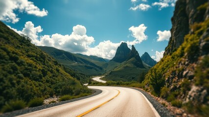 Fototapeta premium Asphalt ribbon winding through a scenic mountain pass under a vibrant summer sky