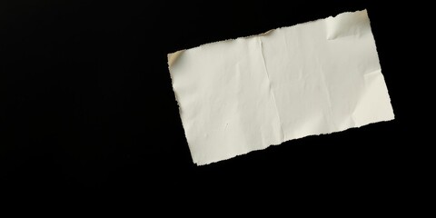 Obraz premium A torn piece of off-white paper floats against a stark black background