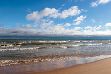Under both blue skies and distant clouds, the waves of Lake Michigan wash onshore at Harrington Beach State Park, Belgium, Wisconsin in mid-November