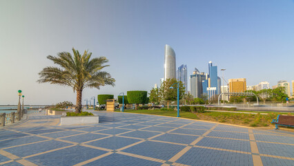 Corniche boulevard beach park along the coastline in Abu Dhabi timelapse hyperlapse with skyscrapers on background.