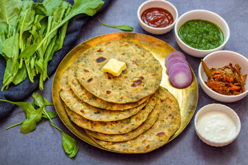 Palak paratha is a soft, spinach-filled flatbread, served with creamy, spiced palak paneer—a flavourful spinach and cottage cheese curry.