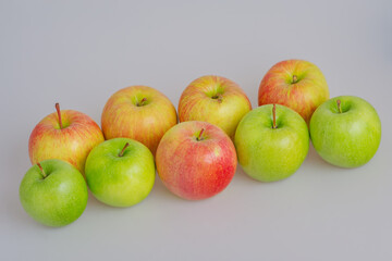 Red and green apples on a gray background.