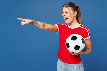 Young angry sad woman fan wear basic red t-shirt cheer up support football sport team hold in hand...