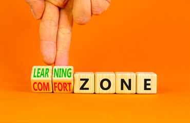 Comfort or learning zone symbol. Concept words Comfort zone Learning zone on wooden cubes. Beautiful orange background. Psychologist hand. Business and comfort or learning zone concept. Copy space.