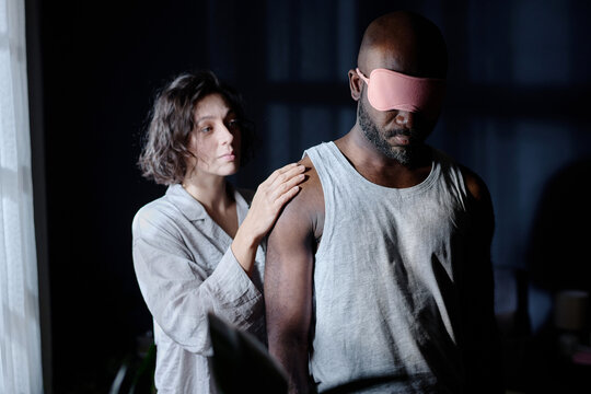 Caucasian woman touching gently her husband who suffering from somnambulism