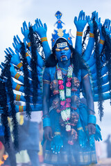 Kulasai Dasara, Portrait of indian male with painted face and dressed as hindu goddess kali to...