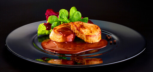 Schweinefleisch mit Rotwein Pfeffersauce auf schwarzem Teller, fine dining, Bratensauce, 