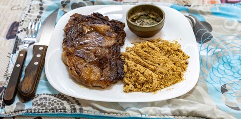 Typical Brazilian lunch with grilled steak, farofa and sauce