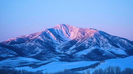 A serene mountain landscape at dawn, featuring snow-covered peaks illuminated by soft, warm light against a pastel sky.