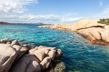Amazing crystal-clear emerald blue turquoise Mediterranean sea touches the rocky coast in Sardinia.